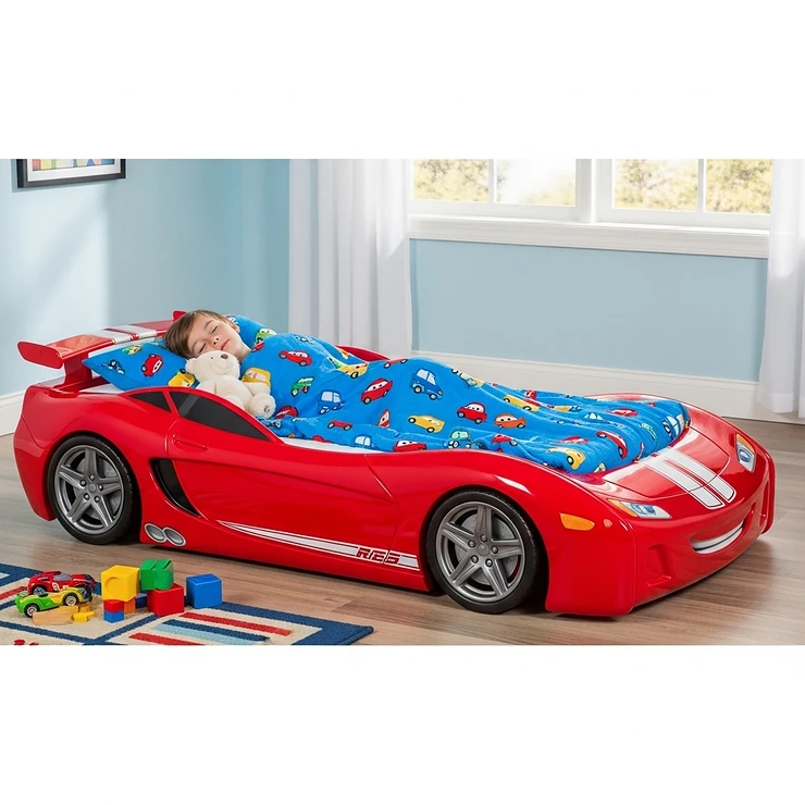 A happy child sleeping comfortably in a full size car bed, showing the bed's practical use and appeal to young car enthusiasts.