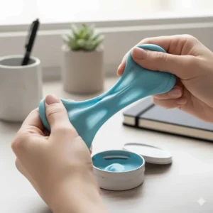 A small tin of light blue therapy putty being kneaded and stretched by a person's hands, highlighting a completely silent fidget for adults and students.