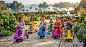 Two young children smiling and racing side-by-side on their respective plasma car for toddlers models in a park.