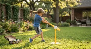 A boy practicing his swing with a plastic backyard baseball bat and tee set on the grass.