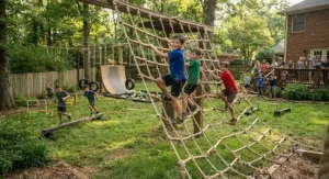 Young boys racing through a ninja warrior style backyard obstacle course featuring climbing nets and ropes